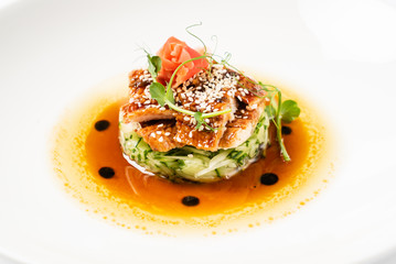 Fried eel with vegetables on the white plate