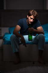 Man drinking in the bed under stress