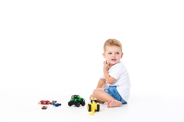 Cute boy plaing with toy car on floor, isolated on white
