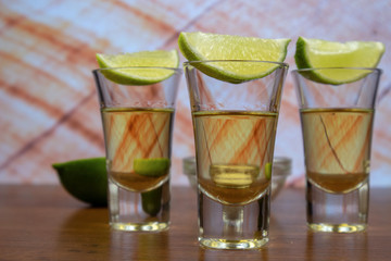 Gold tequila shot and lime slices