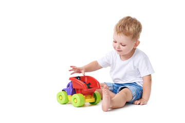 Cute boy plaing with toy car on floor, isolated on white