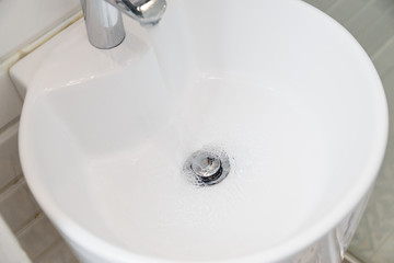 Drain chrome valve in white washbasin