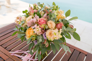 pink and peach wedding bouquet is on the table