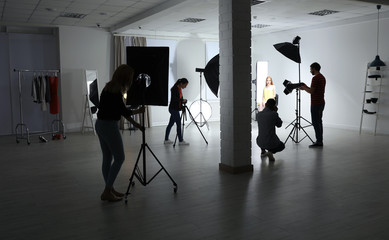 Photo studio with professional equipment and team of workers