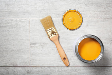 Flat lay composition with can of paint and brush on wooden background. Space for text