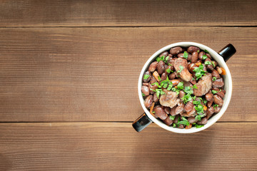 Cooked legumes meat in a bowl on an old wooden table. National dish Asia, Europe, America
