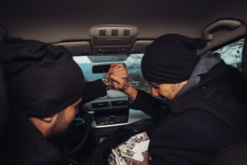 After the successful bank robbery, the thieves are sitting in the car showing off their money and...