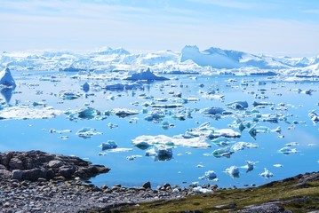 Ilulissat, Greenland, July | UNESCO world heritage site | impressions of Jakobshavn | Disko Bay Kangia Icefjord | huge icebergs in the blue sea on a sunny day | climate change - global warming