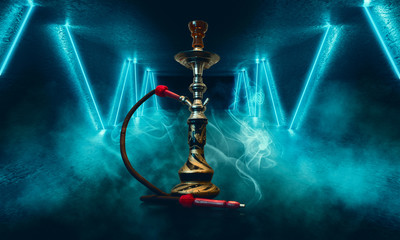 Smoking hookah on the background of an empty room, blue neon light, smoke