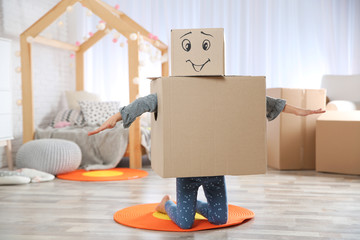 Fototapeta premium Cute little child wearing cardboard costume in bedroom