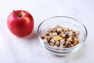 Healthy breakfast with banana, apple and Fresh granola, muesli in bowl on textile background. Top view.
