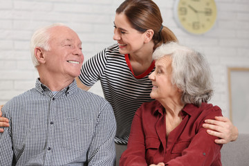Elderly couple with female caregiver at home