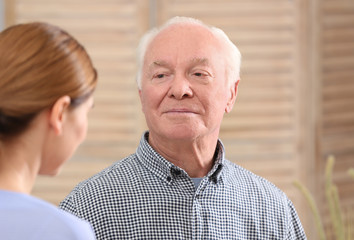Elderly man with female caregiver at home