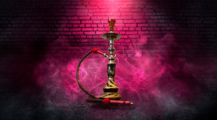 Smoking hookah on the background of a brick wall. Red neon light, smoke, smog