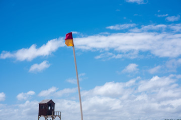 Lifeguard flag against clear blue sky