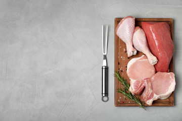 Flat lay composition with fresh raw meat and space for text on gray background