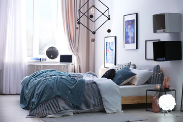 Stylish room interior with comfortable bed and decor