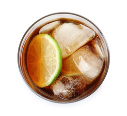 Glass of cocktail with cola, ice and cut lime on white background, top view