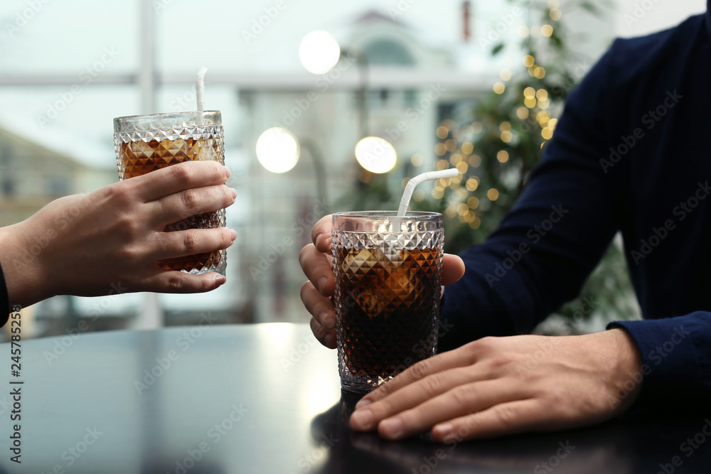 Canvas Prints Couple with glasses of cold cola at table in cafe, closeup