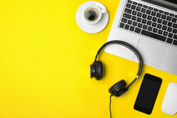 Flat lay composition with headphones, smartphone, laptop and space for text on color background
