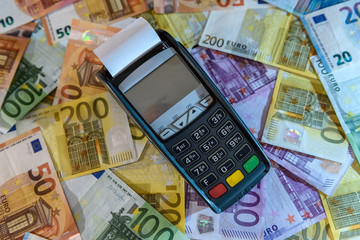 Credit card in terminal at euro banknotes background