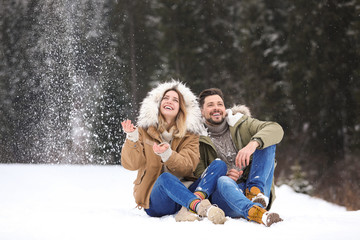 Couple spending time outdoors on snowy day. Winter vacation