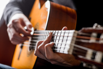 Obraz premium dorosły biały facet grający na gitarze akustycznej. Fotografowanie z podświetleniem