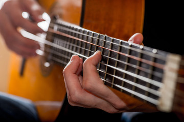 Obraz premium adult white guy playing an acoustic guitar. Backlit shooting