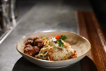 Plate with rice and meat balls served on table