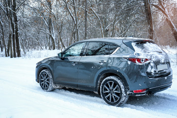 Obraz na płótnie Canvas Snowy country road with car on winter day