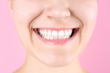 Young woman with beautiful smile on color background, closeup