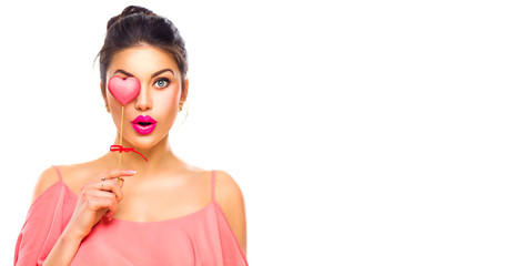 Valentines Day. Beauty joyful young fashion model girl with Valentine heart shaped cookie in her hand isolated on white