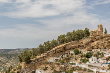 The spectacular Spanish town of Montefrio with its whitewashed houses and its sixteenth century clifftop church, the Iglesia de la Villa, in the Granada region of Andalucia.