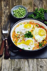 Delicious Shakshuka on the wooden background. Healthy eggs breakfast 
