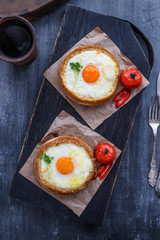 Round khachapuri on black woden cutting board, top view
