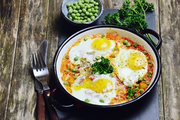 Delicious Shakshuka on the wooden background. Healthy eggs breakfast 