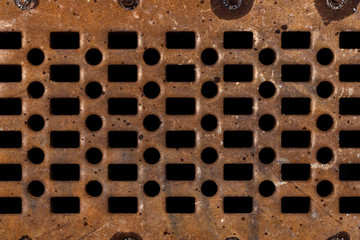 Old rusty and perforated manhole cover background texture