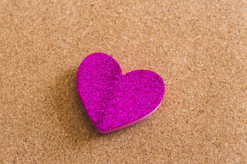 Top view of a velvet heart shape over a craft background