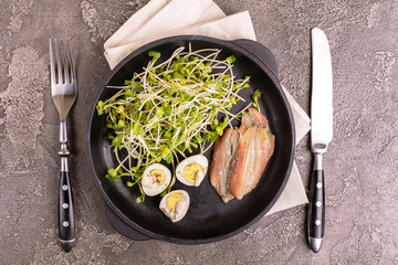 Unusual salad with leek sprouts, quail eggs and anchovies