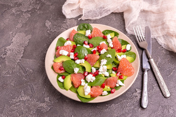 Tasty salad with grapefruit, spinach, feta, avocado and pomegranate