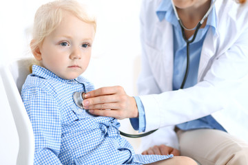 Doctor and a little blonde girl. Usual health exam. Medicine and healthcare concept