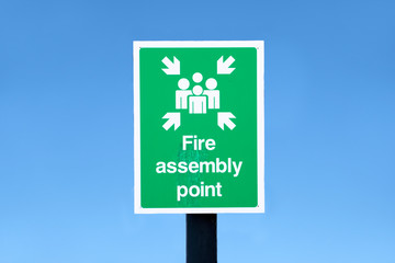 Fire assembly point sign and blue sky at workplace
