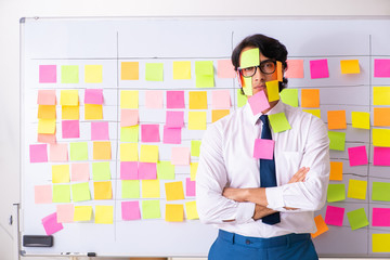 Young employee in conflicting priorities concept 