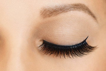 Female eye with long false eyelashes. Eyelash extensions, make-up, cosmetics, beauty