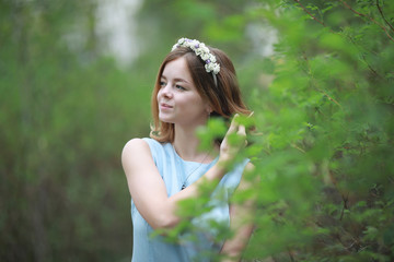 Girl in blue dress in green park
