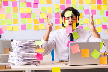 Young employee in conflicting priorities concept 