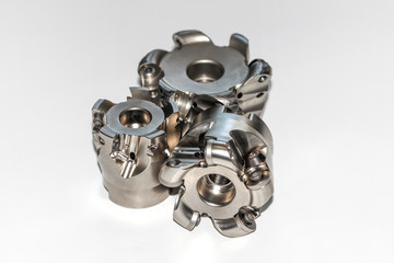 Naklejka premium Two undamaged and one damaged indexable milling cutter for CNC milling machine with selective focus isolated on white