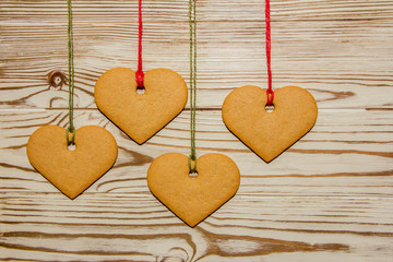 Handmade heart shaped cookies, tied to a rope on a wooden background  for a Valentine, Christmas or any holiday of loving people