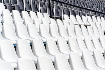 Empty black and white stadium seats mixed in rows, diversity concept
