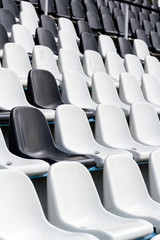 Empty black and white stadium seats mixed in rows, diversity concept